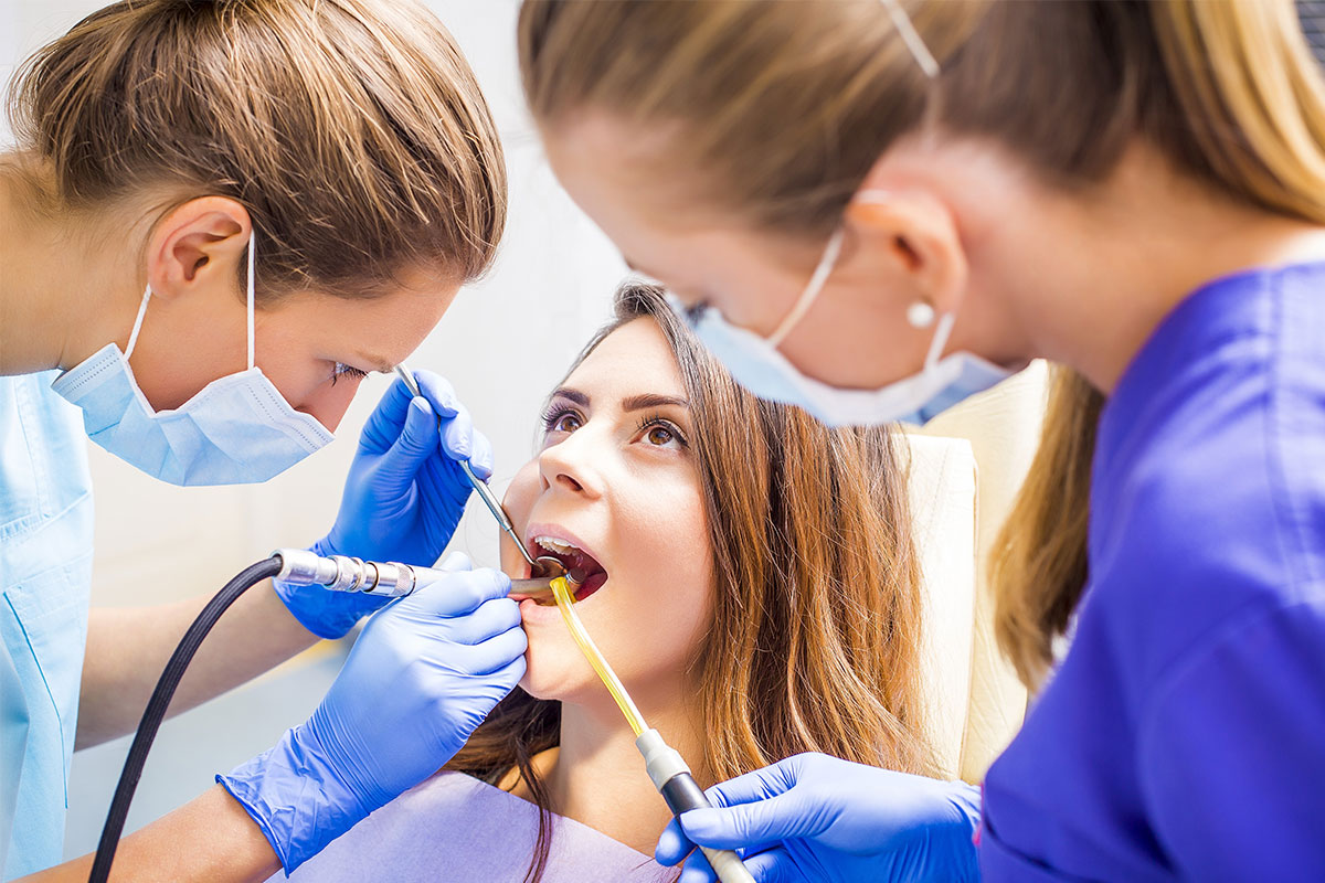 Lady dentists filling the patient's tooth