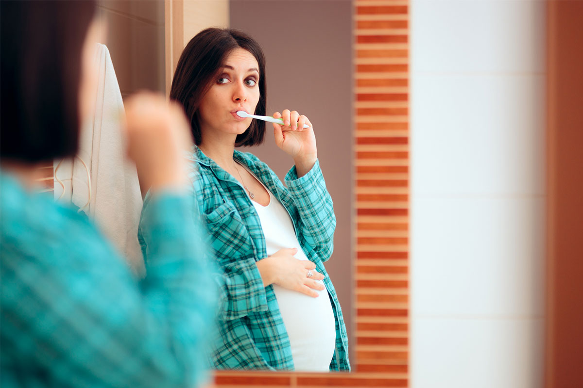 Pregnant woman brush her teeth